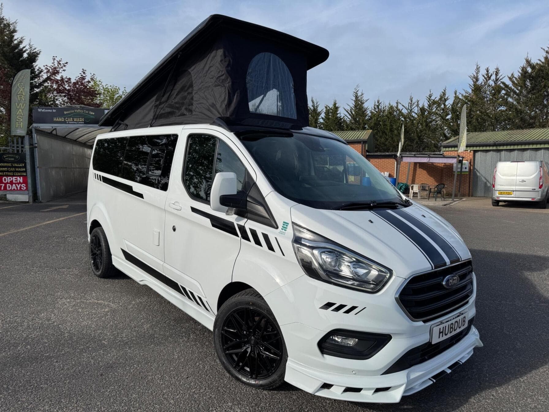 HubDub campervan conversion in white with black bonnet stripes, a 2022 Ford Transit Custom Limited with the pop-top raised